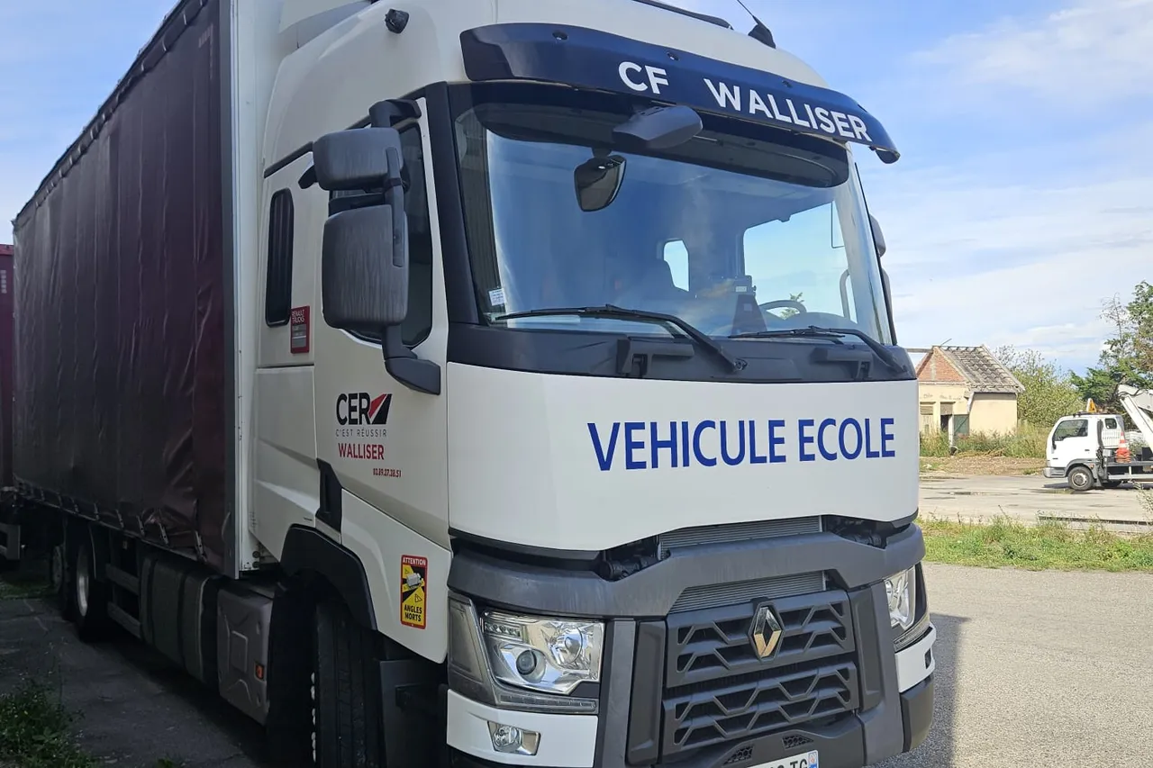 Le camion-ecole du centre, un Renault T porte-CF Walliser, vu de trois quarts avant avec sa remorque attelee.