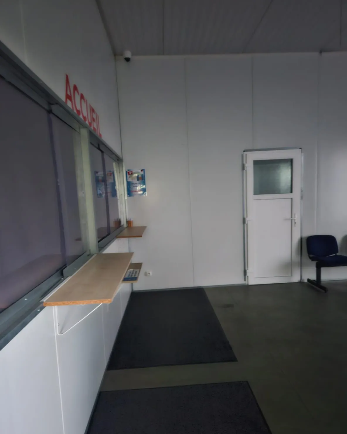 Le couloir et le guichet d’accueil, signalé par l’inscription « Accueil » en lettres rouges.